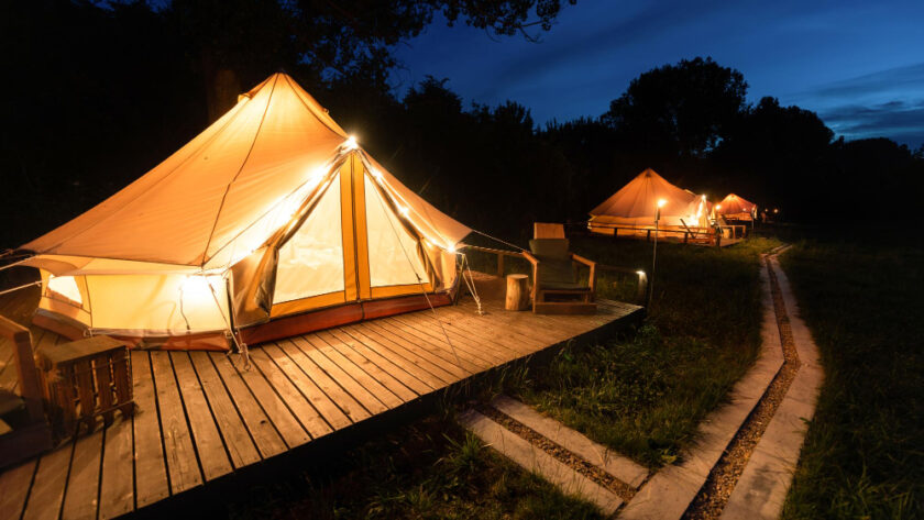 Une tente éclairée dans la nuit dans un camping